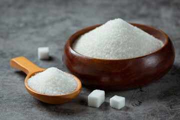 Fototapeta na wymiar World diabetes day; sugar in wooden bowl on dark background