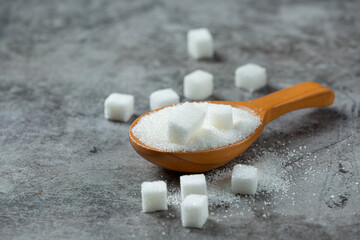 World diabetes day; sugar in wooden bowl on dark background