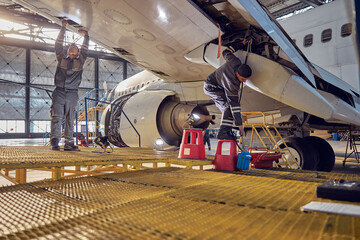 Technical aviation specialists fixing flight control surfaces