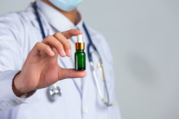 close up picture of medical doctor holding a bottle of cannabis oil on white background.