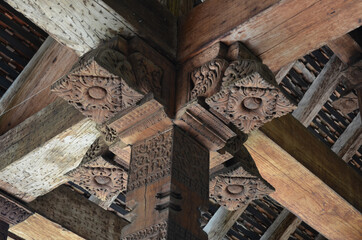 Low angle shot od an old building with wooden frames with engravings