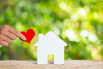 Obraz na płótnie Canvas World Habitat Day,close up picture of a model house and hand holding paper heart