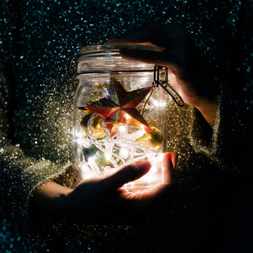 Hands holding christmas decoration light in the glass jar