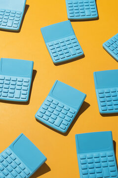 Blue pocket calculators on orange background.