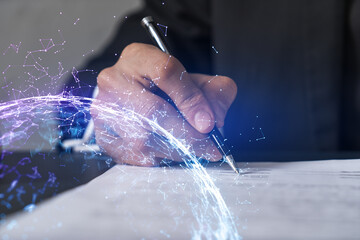 Businessman in suit signs contract. Double exposure with abstract technology hologram. Man signing...