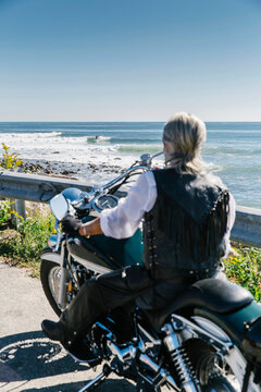 Senior Woman Watching Surfers on Motorcycle