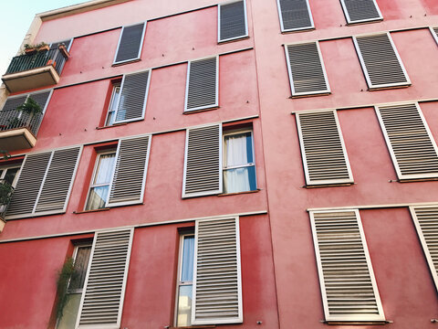 front view of a pastel pink appartment buidling