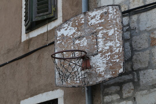 Old Basketball Ring Is Attached To The Wall Of The House