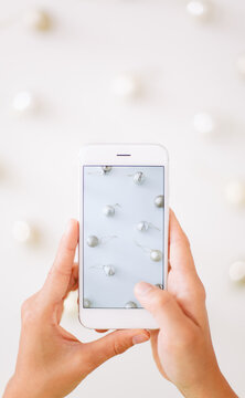 Woman using phone camera take a picture of Christmas ball