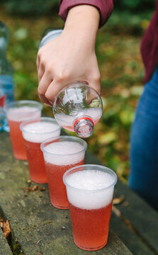 Pouring four cups of fizzy drink