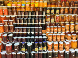 Rows with jars of honey, nuts, jam. Sale on the street on the way to the monastery