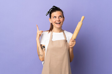 Cooker Slovak woman isolated on purple background pointing up and surprised