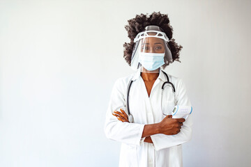Shot of a female doctor holding an infrared thermometer. Doctor wearing protective surgical mask...