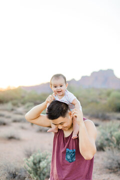 Happy baby sitting on dads shoulders