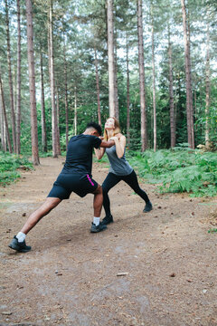 Man and woman exercising in woodland