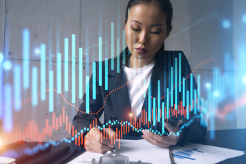 Businesswoman taking notes and forex graph hologram. Double exposure. Business technology online trading stock market solution concept.