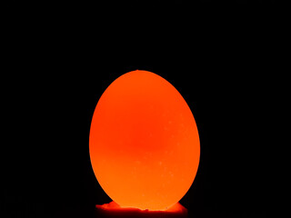 The light is on the back of the egg and the egg is bright yellow.