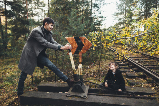 Father and daughter playing on old railroad