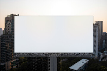 Obraz premium Blank white road billboard with Bangkok cityscape background at sunset. Street advertising poster, mock up, 3D rendering. Front view. The concept of marketing communication to promote or sell idea.