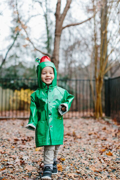 Cute young boy running around in a frog raincoast