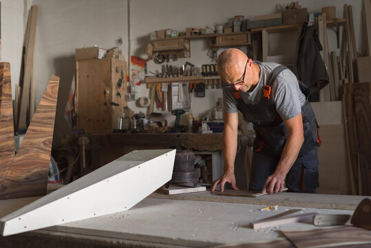 Carpenter adding glue to a piece of veneer - Powered by Adobe