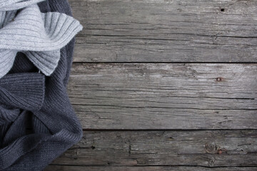 Grey scarfs on shabby old wooden boards. Copy space, top view. Autumn background, fall season, winter, warm cloth concept