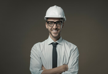 Confident architect smiling and wearing a safety helmet