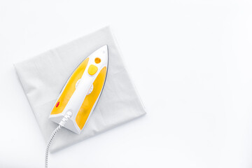 Household laundry ironing concept. Iron with clothes top view