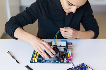 Woman repairing a motherboard of computer