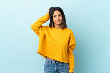 Caucasian girl isolated on blue background with an expression of frustration and not understanding