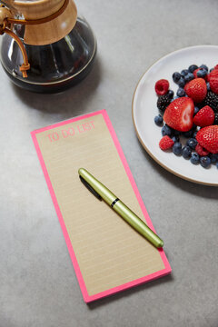To do list and pen on kitchen counter with breakfast