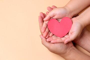 Obraz premium hands holding paper red heart,Concept of health in the family.