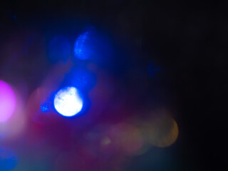 Trendy black neon colors festive sparkling defocused lights. Blue, yellow and purple bokeh. Perfect stylish abstract overlay footage. Christmas New Year bright blinking flashing colorful background.