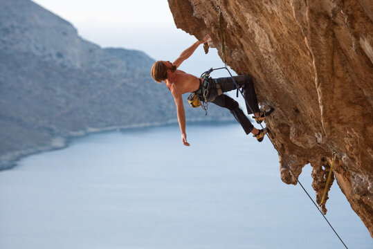 Powerful rock climber on a overhanging wall