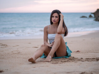 Fototapeta na wymiar Mujer joven posando en la playa durante el atardecer