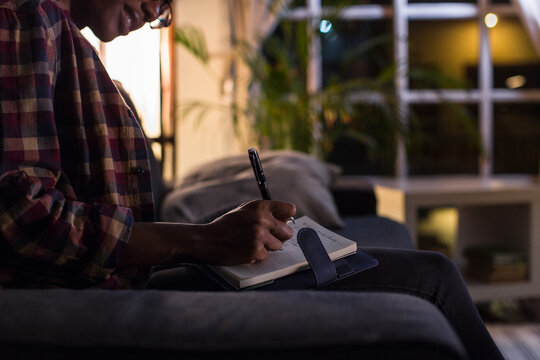 Woman writing her dairy at home