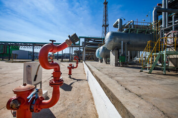 Petrochemical plant. (Oil refinery plant). Red fire extinguisher and heat exchangers, pipelines and...
