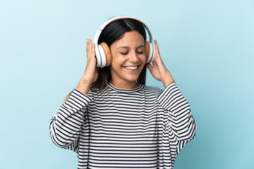 Caucasian girl isolated on blue background listening music