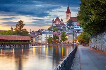 Thun, Switzerland. Cityscape image of beautiful city of Thun with the reflection of the city in the Aare river at sunset.