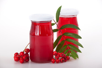 Two jars of red rowan jelly and a cluster of rowan berries