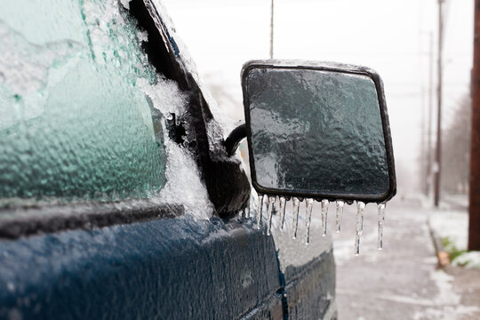 Passenger side mirror on pickup truck frozen over with icicles