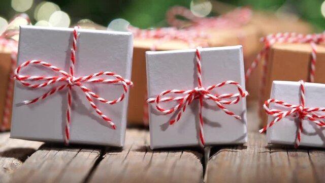 Christmas gifts, pan on old wooden table, bokeh lights background