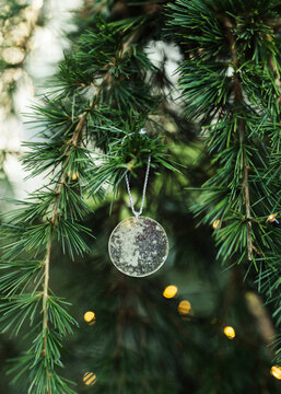 Ancient round mirror decoration hanging close to lights on Christmas tree