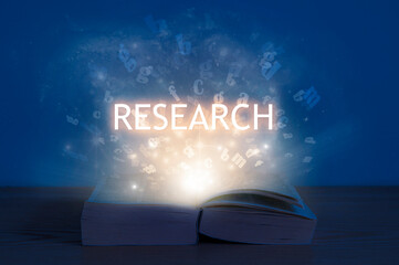 Research, education concept. Light coming from open book with word research.