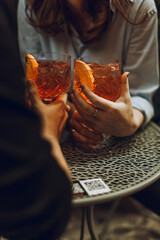 Young couple toasting with aperol spritz cocktails