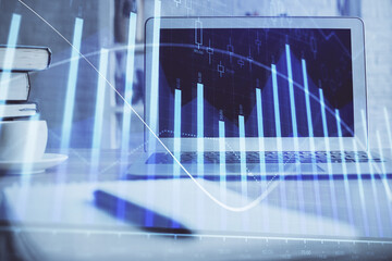 Stock market graph on background with desk and personal computer. Multi exposure. Concept of financial analysis.