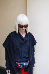 Portrait of a blonde girl in red pants in the yard