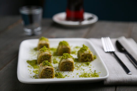 Dolama Baklava with pistachio on a white plate with tea