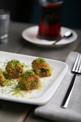 Burma Kadayif with Pistachio on a white plate vertical view
