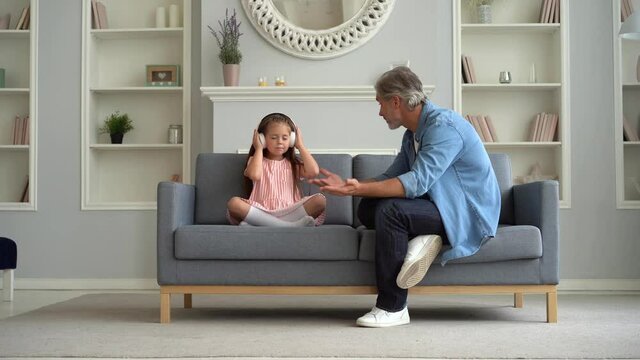 Difficult child. Father scolds naughty daughter